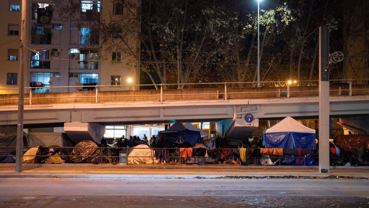 Miembros de Cruz Roja realizan un cribaje de las personas desalojadas del instituto B9 que duermen bajo el puente de la autopista C-31