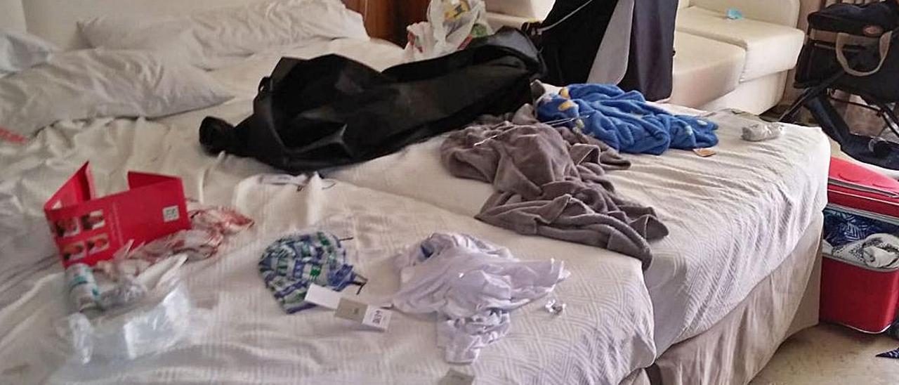 Ropa, basura y suciedad por encima de camas y mesas en la habitación de un hotel de Benidorm.