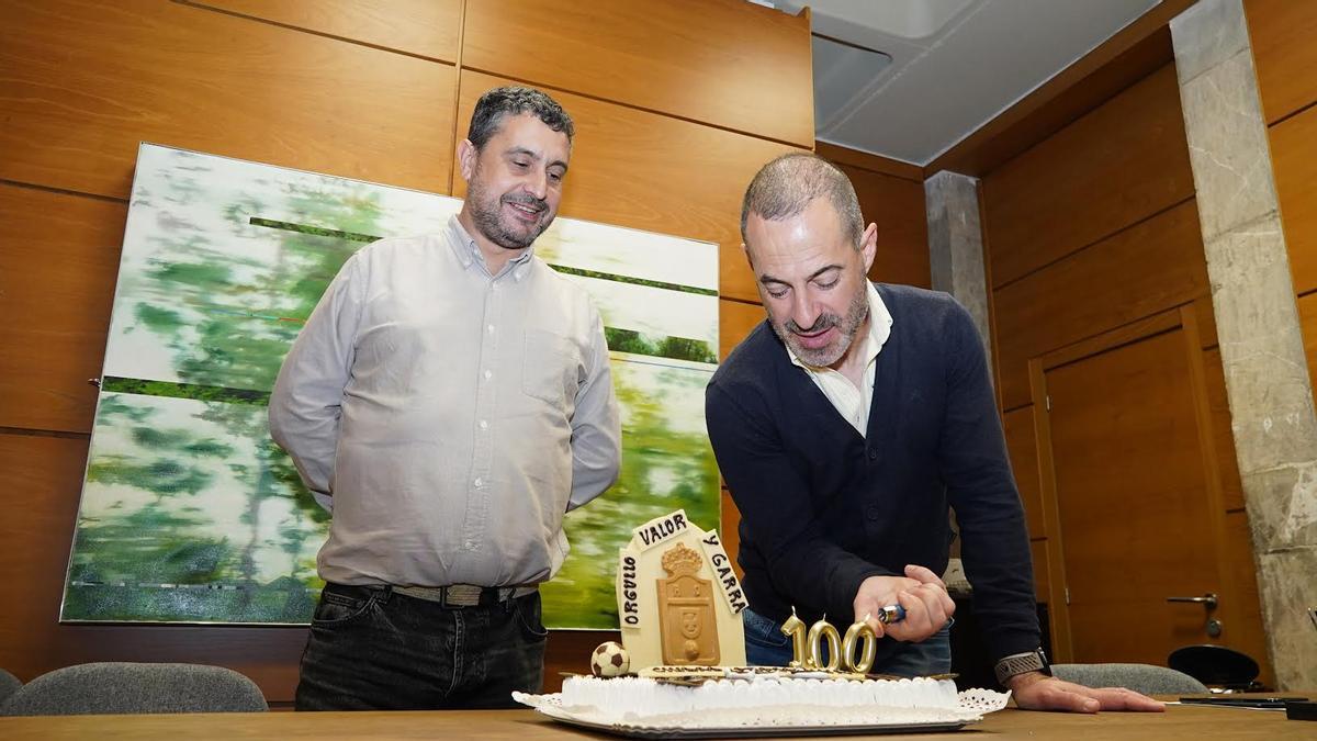 Ángel García enciende las velas de la tarta del centenario del Oviedo en presencia del edil Javier Rodríguez.