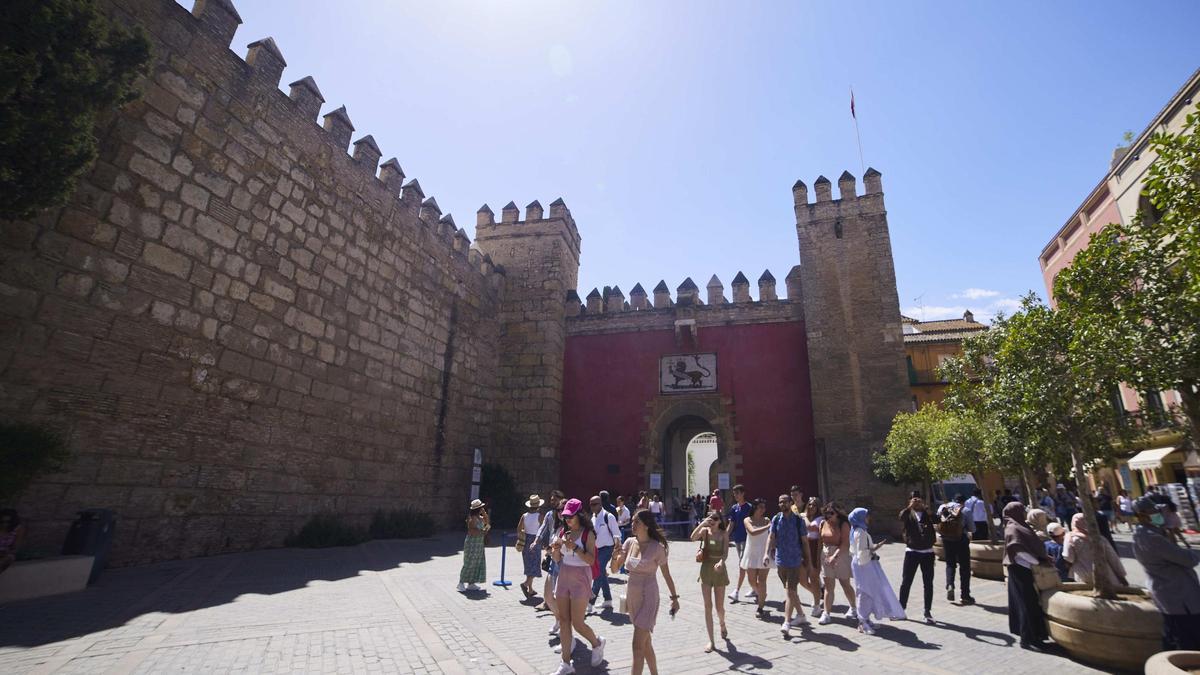 Un grupo de Turistas pasan por delante de la entrada del Real Alcázar