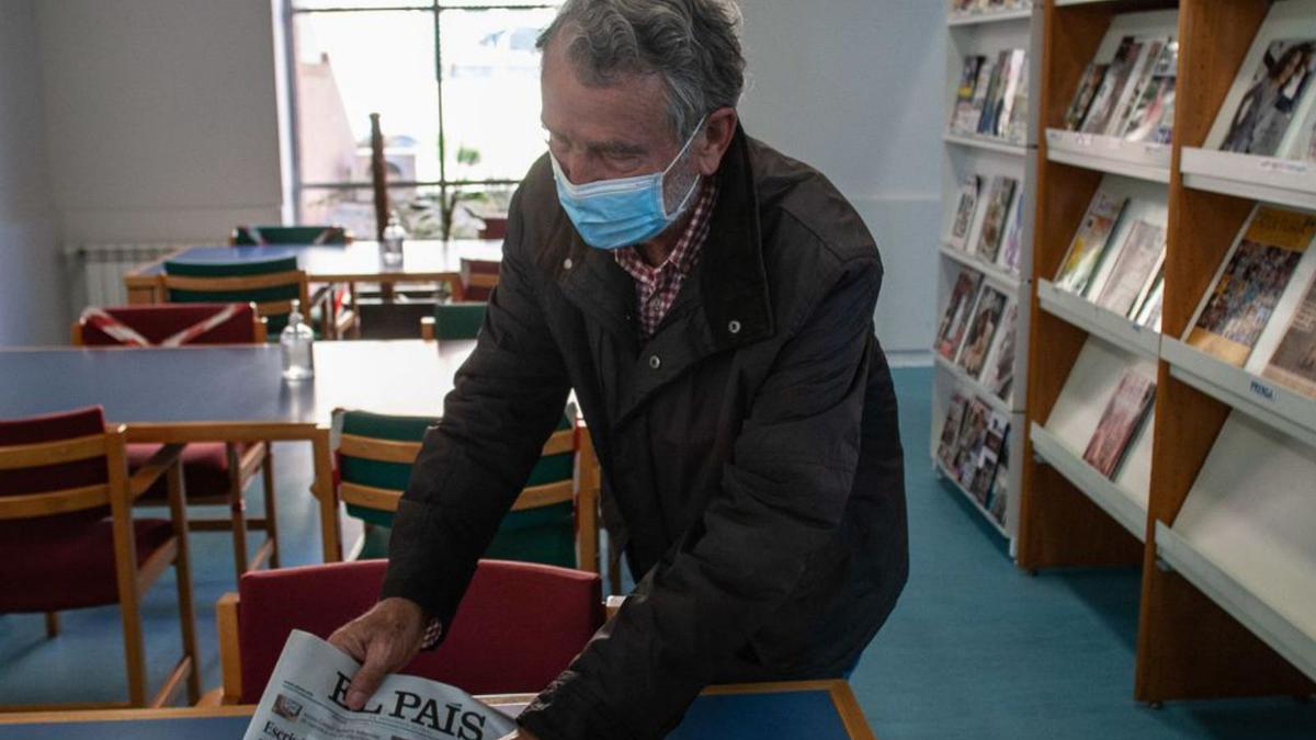 Un usuario escoge un periódico en la sección de lectura. | Emilio Fraile