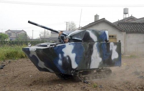 Jian waves in his home-made replica of a tank during a trial run, at a village in Mianzhu