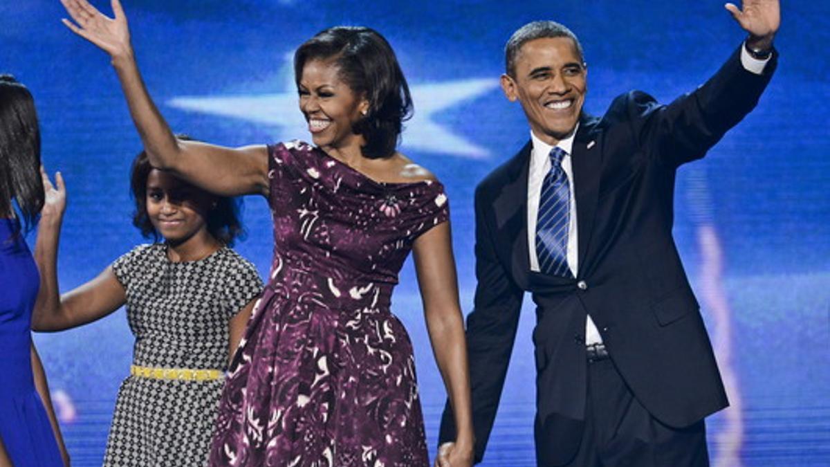Barack Obama y su esposa, Michelle, saludan tras el discurso del presidente, anoche en Charlotte.