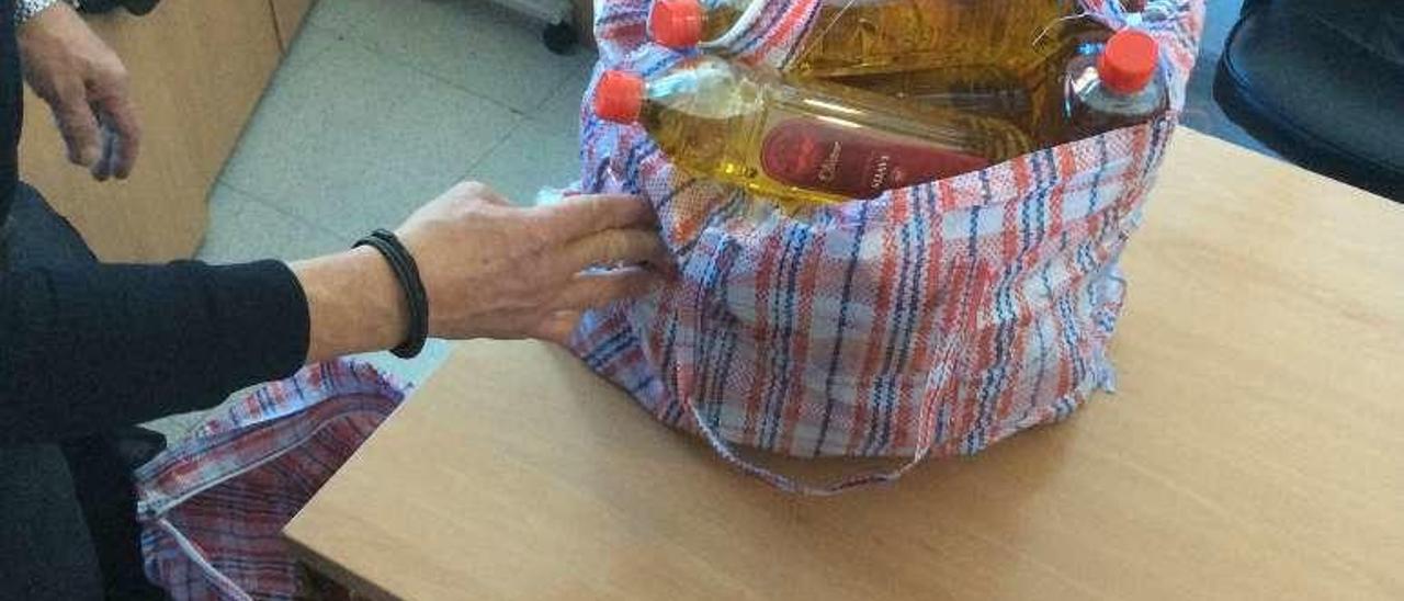 Bolsas con botellas de aceites incautadas al sospechoso. // G.N.