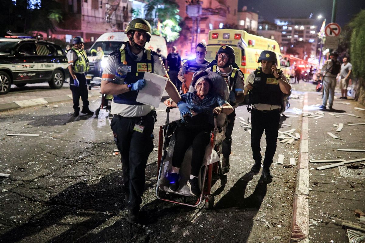 Rescue personnel evacuate a wounded woman at an impact site following missile attack from Iran on Israel, in Ramat Gan, Israel  June 13, 2025 REUTERS/Itai Ron ISRAEL OUT. NO COMMERCIAL OR EDITORIAL SALES IN ISRAEL. ISROUT