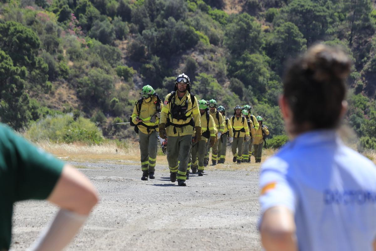 Bomberos forestales a su llegada el jueves al puesto de mando de Benahavís, donde les esperaba los sanitarios, tras pasar la noche luchando contra el fuego.