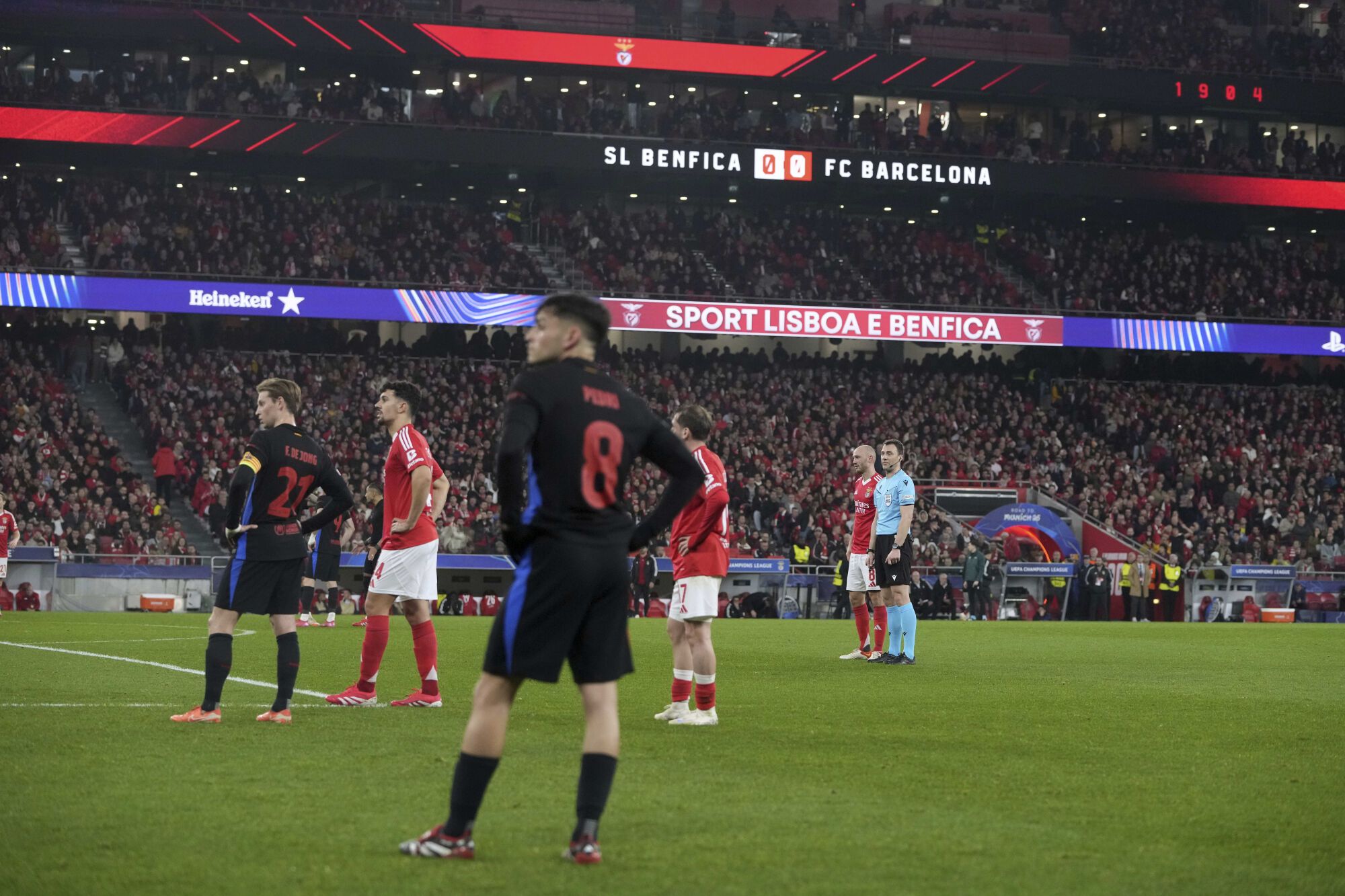 Players watch Benfica fans light flares during the Champions League round of 16 first leg soccer match between SL Benfica and FC Barcelona at the Luz stadium in Lisbon, Wednesday, March 5, 2025. (AP Photo/Armando Franca)
