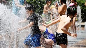 Niños de un casal del barrio de Horta, se refresca en una fuente.