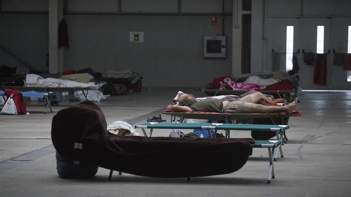 Temporeros durmiendo en el pavellón de la Fira de Lleida.
