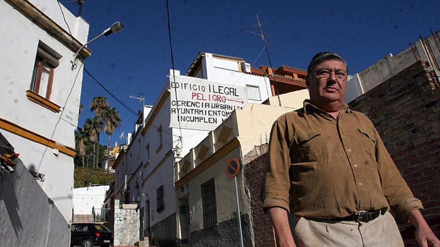 Problemas en El Morlaco. En la foto, Rafael Cueto en la calle Isidro Ruiz del Morlaco, delante del cartel que colgó coincidiendo con las elecciones municipales de 2007, en la que denuncia un supuesto edificio ilegal. Por contra, el concejal de Urbanismo ha asegurado que no hay nada incorrecto y que el Ayuntamiento no puede obligar a retirar la tierra, queja principal de los vecinos.