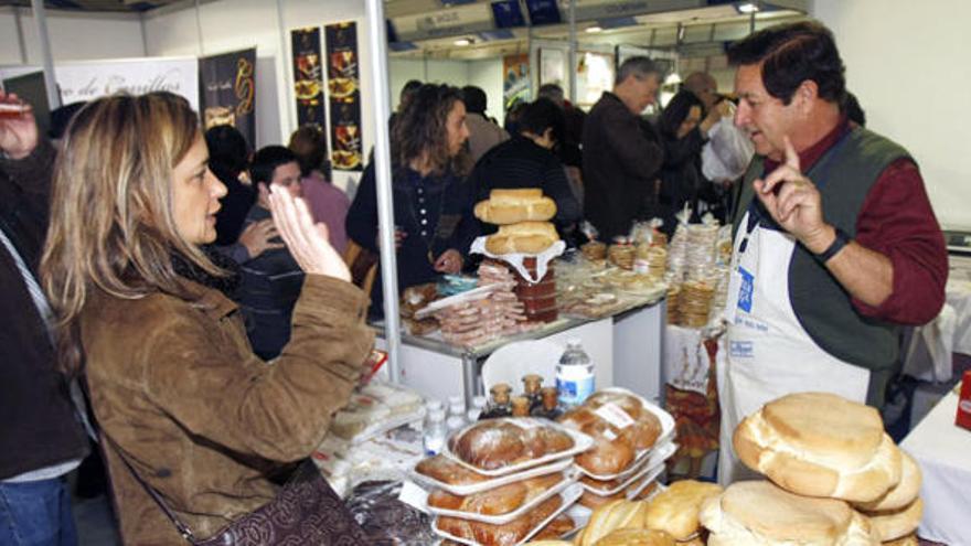 Un tendero explica a una clienta las diferentes variedades de pan y de repostería que tiene en su puesto