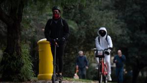 Archivo - Una persona monta en bicicleta y otra en patinete eléctrico, a 13 de diciembre de 2024, en Barcelona, Catalunya (España).