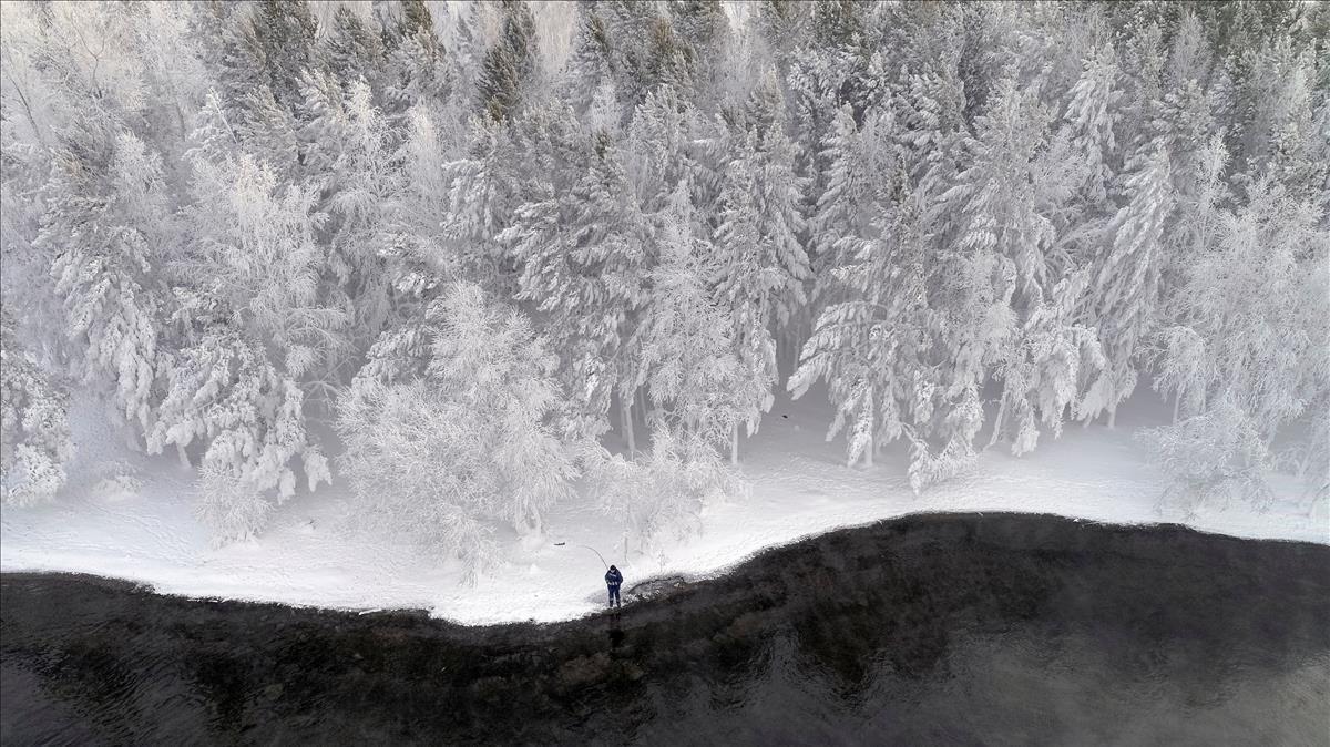 Un hombre pesca en el río Yenisei en Rusia con temperaturas de 16 grados bajo cero.