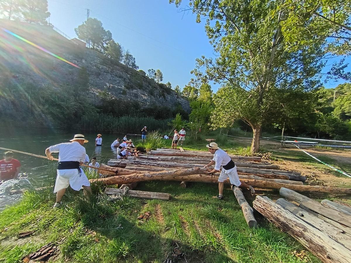 Los 'maeros' preparando los troncos para la bajada del río Xúquer el sábado.