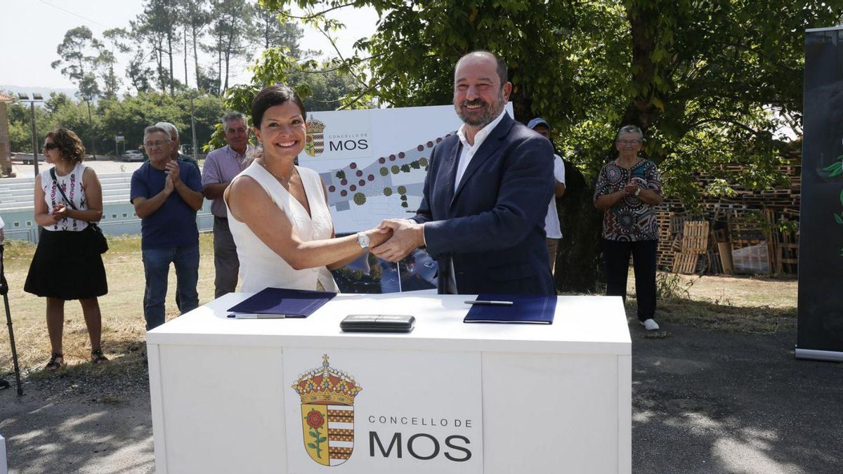 Nidia Arévalo y Xosé Merelles se dan la mano tras la firma del acuerdo.