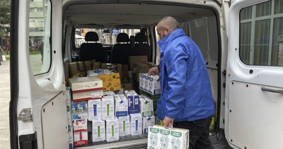 Personal de Cáritas carga alimentos en una furgoneta.