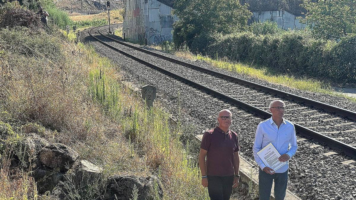 El senador popular, Manuel Baltar y el diputado Celso Delgado entre la maleza de las vías en Vilanova de Canedo, en Ourense.