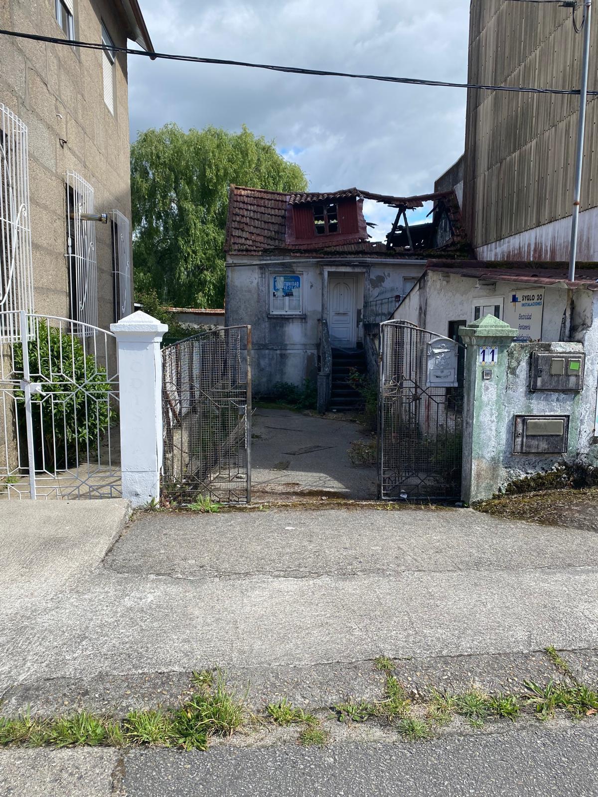 La vivienda abandonada junto a la casa de la vecina en el barrio de Calvar en Domaio.