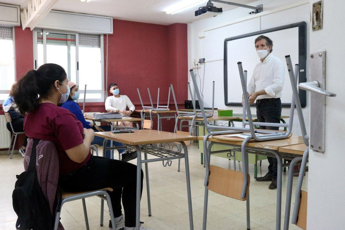 Un profesor habla con varios alumnos de bachillerato