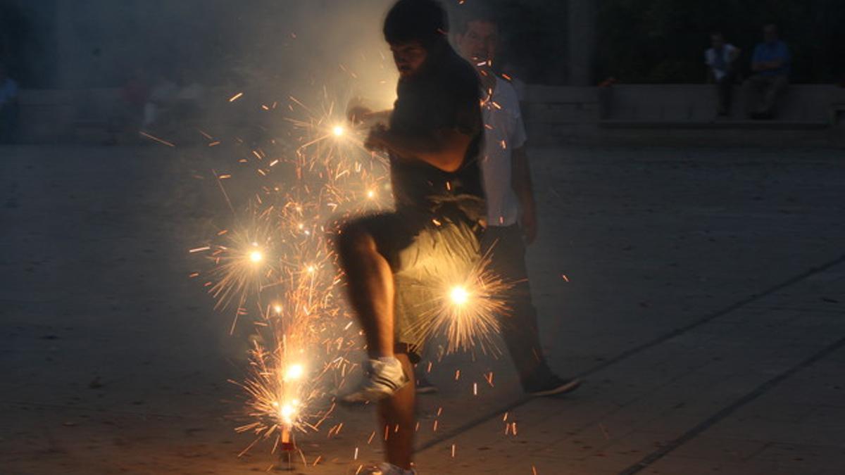 Un joven celebra con petardos la verbena de Sant Joan en Barcelona.