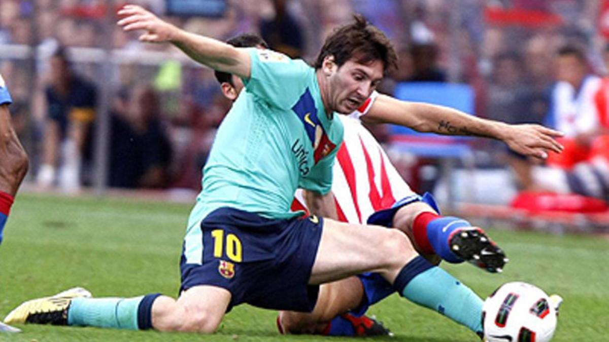 Messi intenta controlar la pelota ante un jugador atlético.