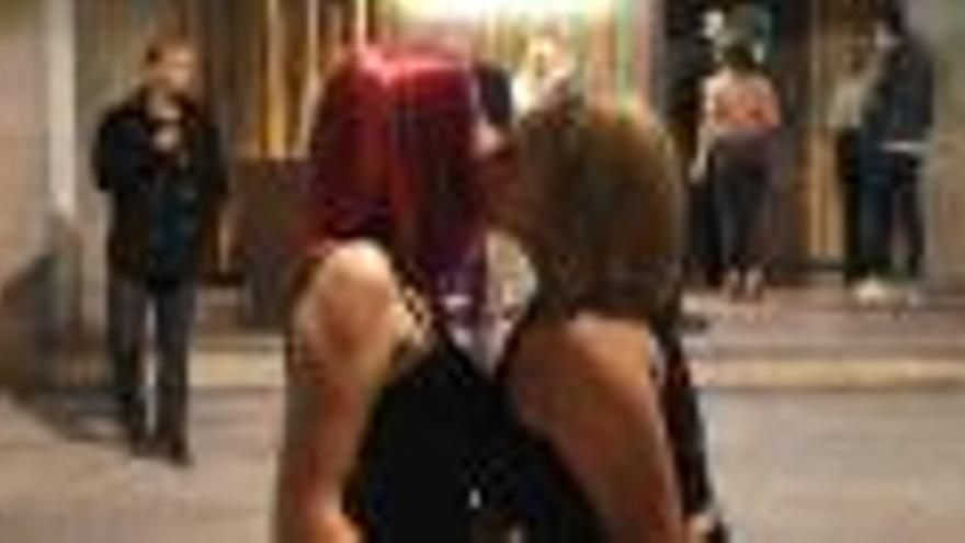 Dues noies fent-se un petó davant d&#039;un local nocturn