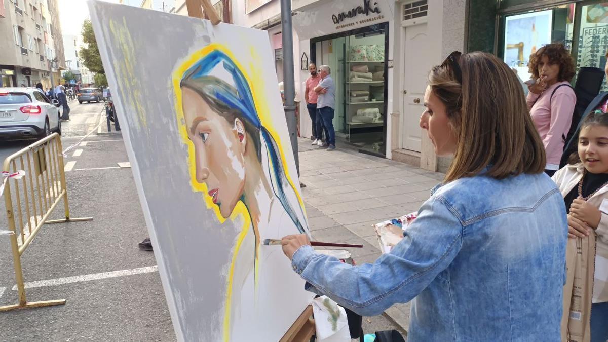 Una artista dibujando en plena calle Francisco Pizarro durante 'Com-Arte'