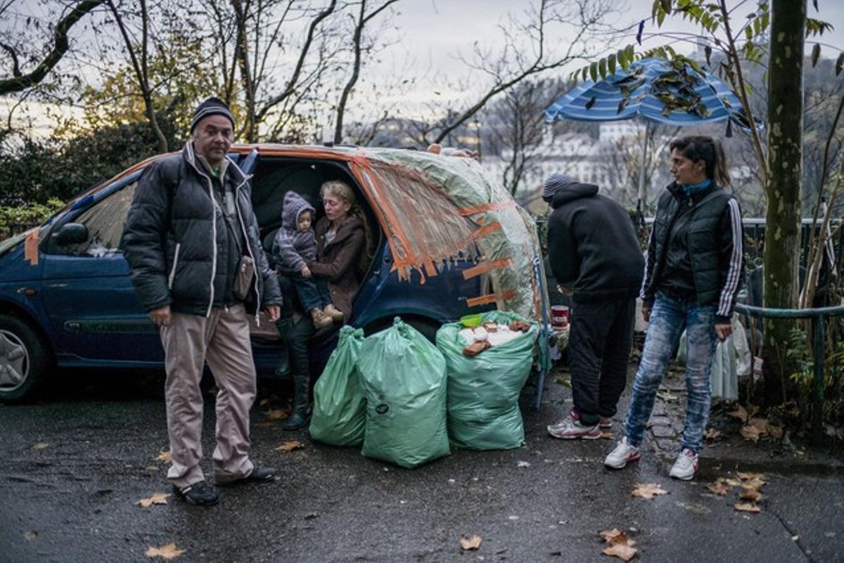 Miembros de familias sin hogar regresan al coche donde viven tras dormir en una escuela ocupada en Lyon.