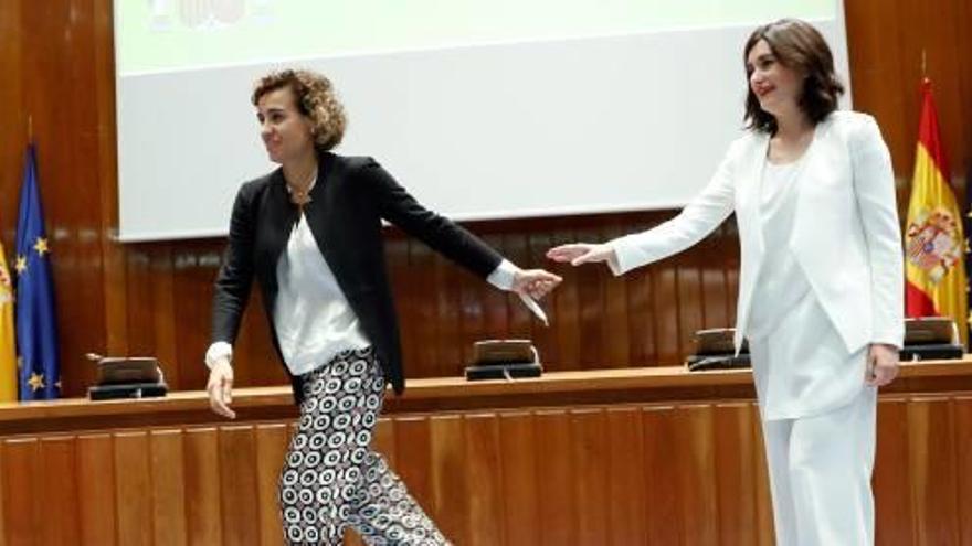 La ministra Carmen Montón, de blanco, despide a su antecesora, Dolors Montserrat, en la ceremonia de traspaso de cartera, ayer.