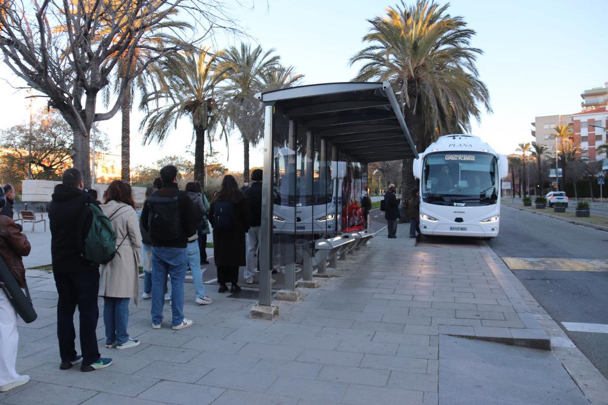 Usuaris del transport públic de Sitges esperen l'autobús per anar cap a Barcelona el primer dia de les obres del túnel del Garraf