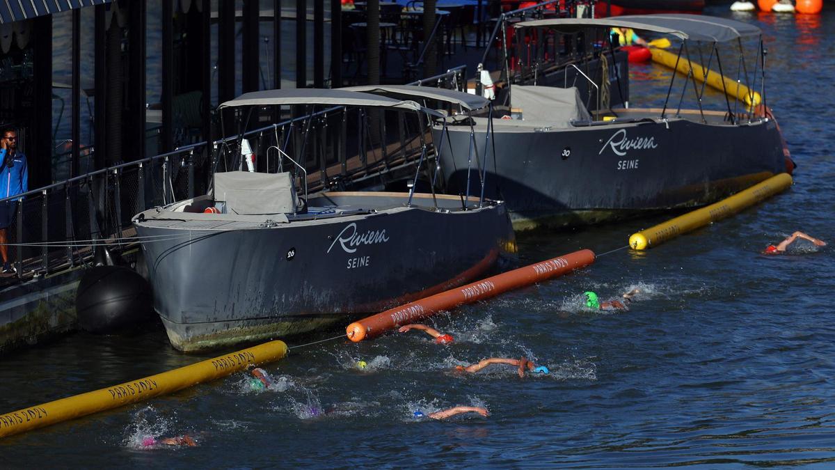 Los atletas compiten en la carrera de natación en el Sena durante el triatlón de relevos mixtos