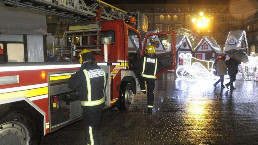 Bomberos en la plaza de María Pita por problemas por el viento en una caseta del poblado navideño.