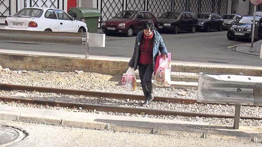 Una mujer cruza la vía del tren de Sóller en la calle de la Concòrdia.