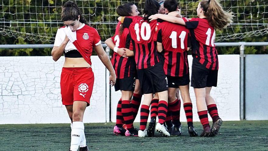 Una jugadora del Girona està capcota mentre el Pallejà celebra un gol.