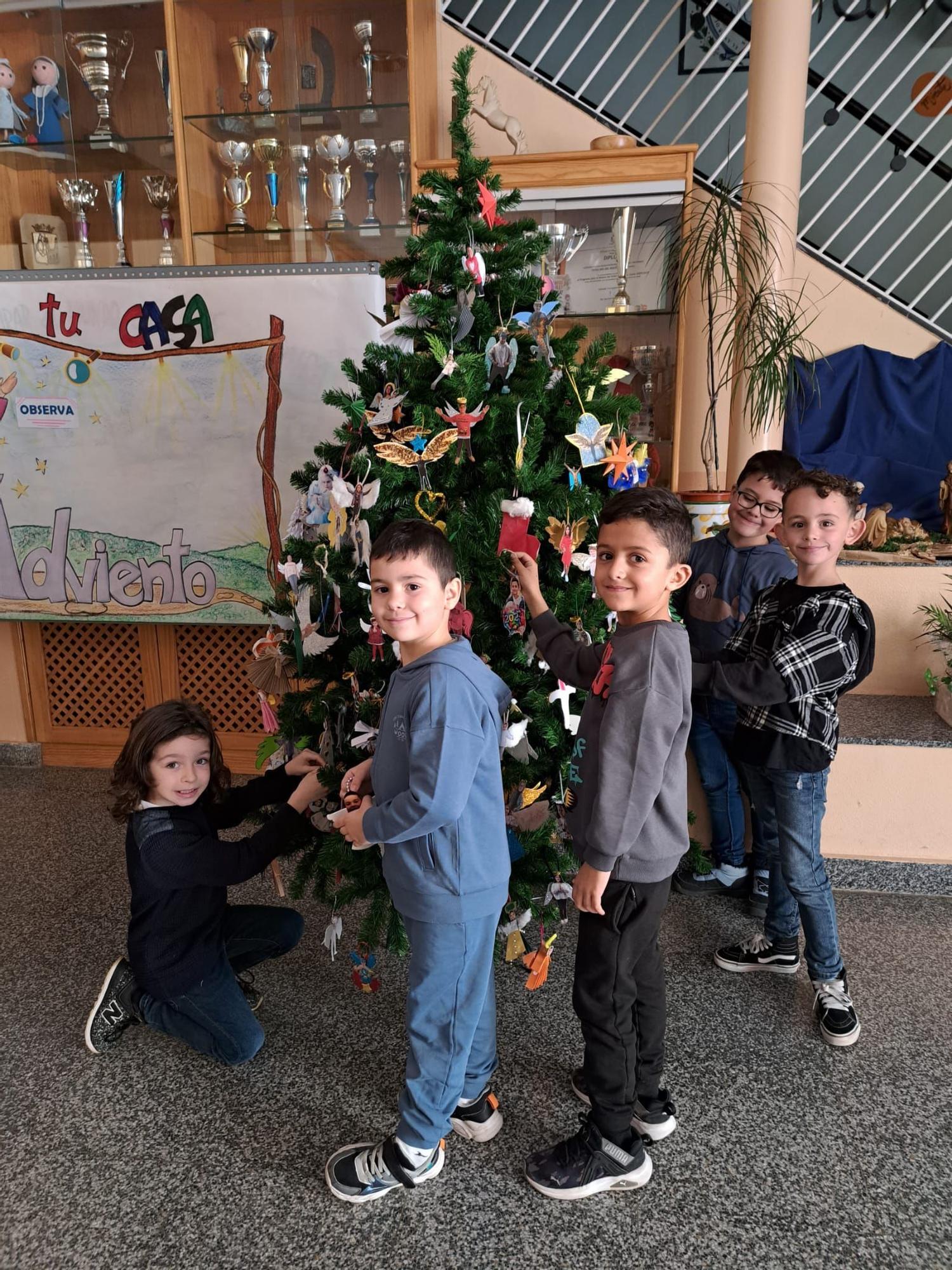 Varios niños decoran el árbol de Navidad