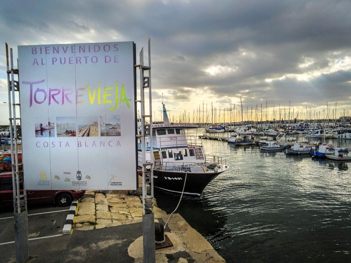 Detrás del cartel se aprecian los sillares del antiguo muelle