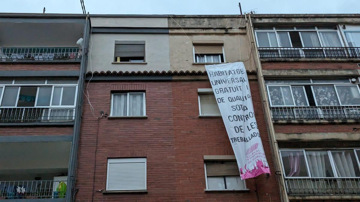 El Sindicato de Vivienda de Valencia despliega una pancarta tras el desahucio de una madre con dos niños por un fondo buitre.