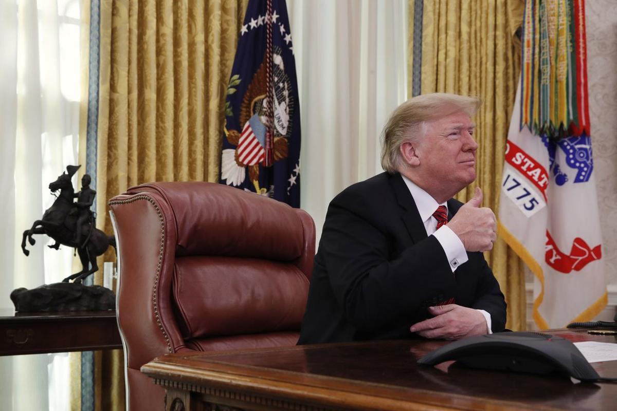 President Donald Trump gives the thumbs up sign while speaking with members of the five branches of the military by video conference on Christmas Day, Tuesday, Dec. 25, 2018, in the Oval Office of the White House. The military members were stationed in Guam, Qatar, Alaska, and two groups in Bahrain. (AP Photo/Jacquelyn Martin)