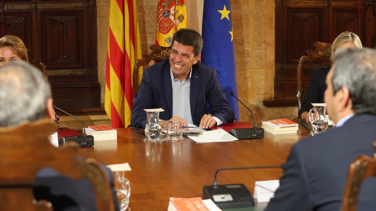Diferencia de Protocolo entre Carlos Mazón, sentado en el centro de la mesa, y Ximo Puig, en la esquina