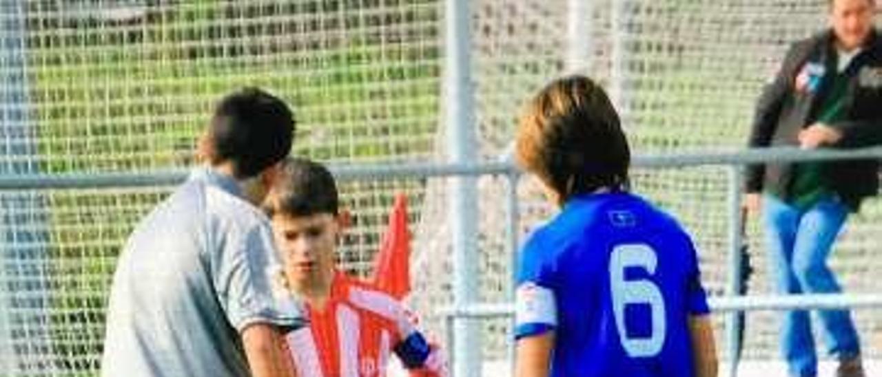 Espeso, de rojiblanco, ante Dani Benítez, en un derbi de Primera alevín.