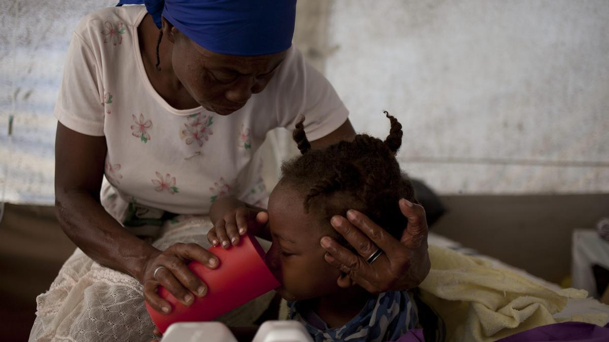 Una madre cuidando a su hija, afectada por el cólera en el hospital Santa Caterina de Cite Soleil, en Puerto Príncipe (Haití).