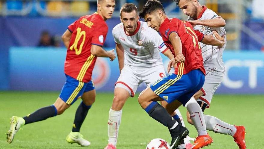 Asensio controla el balón ante dos jugadores de Macedonia y el excéltico Denis Suárez. // Adam Warzawa