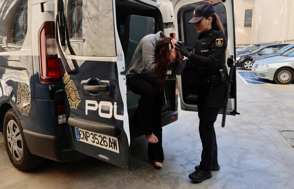 Una agente ayuda a bajar del furgón a la presunta secuestradora para llevarla al juzgado de guardia.