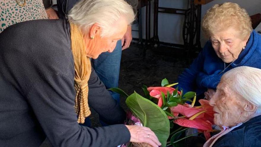 Ceferina, a la derecha de la imagen, recibe la felicitación de vecinos y miembros de la Corporación