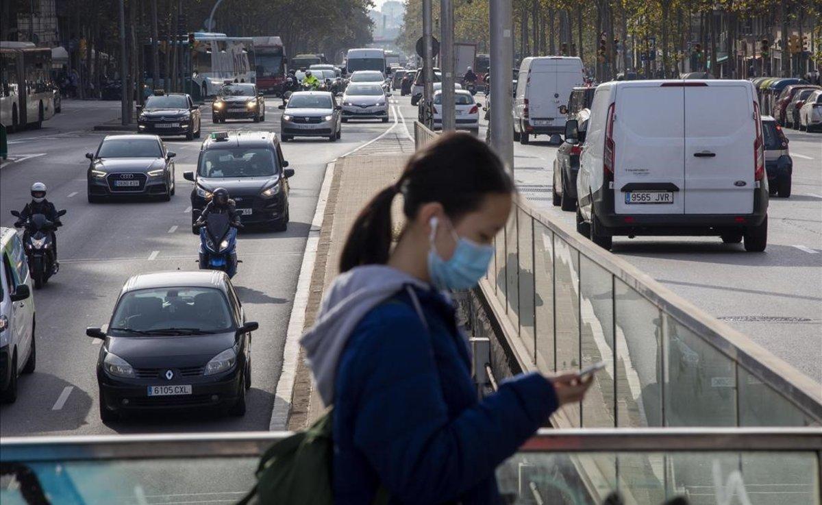 Una chica con mascarilla por las calles de Barcelona.