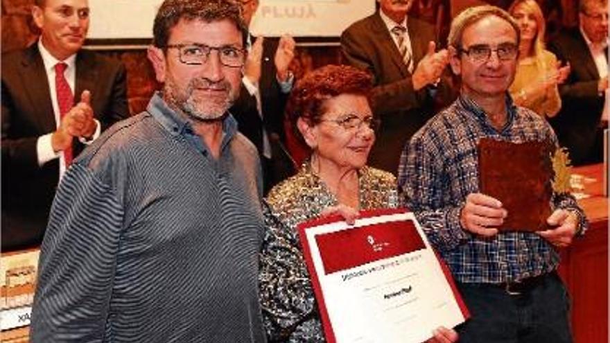 Els responsables de Ferreria Plujà, amb el diploma i la placa que els acredita com a establiment històric.