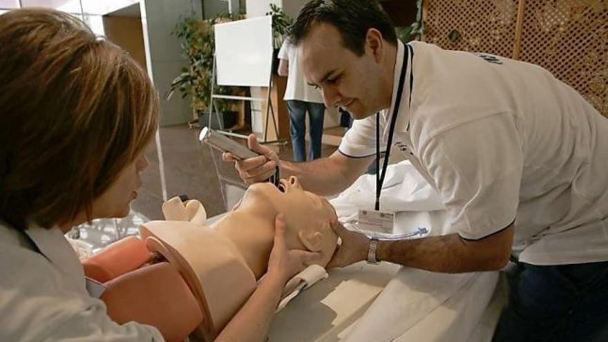 Rosa Encinas e Iván Rancaño, ayer, intubando a un maniquí en el hospital.