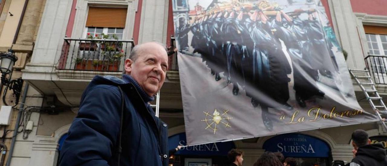 El pintor Favila, junto a la gran lona colocada en la plaza de España ilustrada con uno desu cuadros dedicados a la Semana Santa.