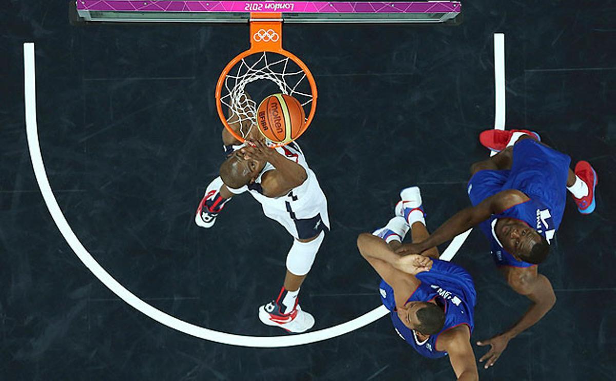 El jugador nord-americà Kevin Durant (centre) salta per sobre dels francesos Boris Diaw i Florent Pietrus en un partit en què la victòria ha estat per als nord-americans per un 98-71.