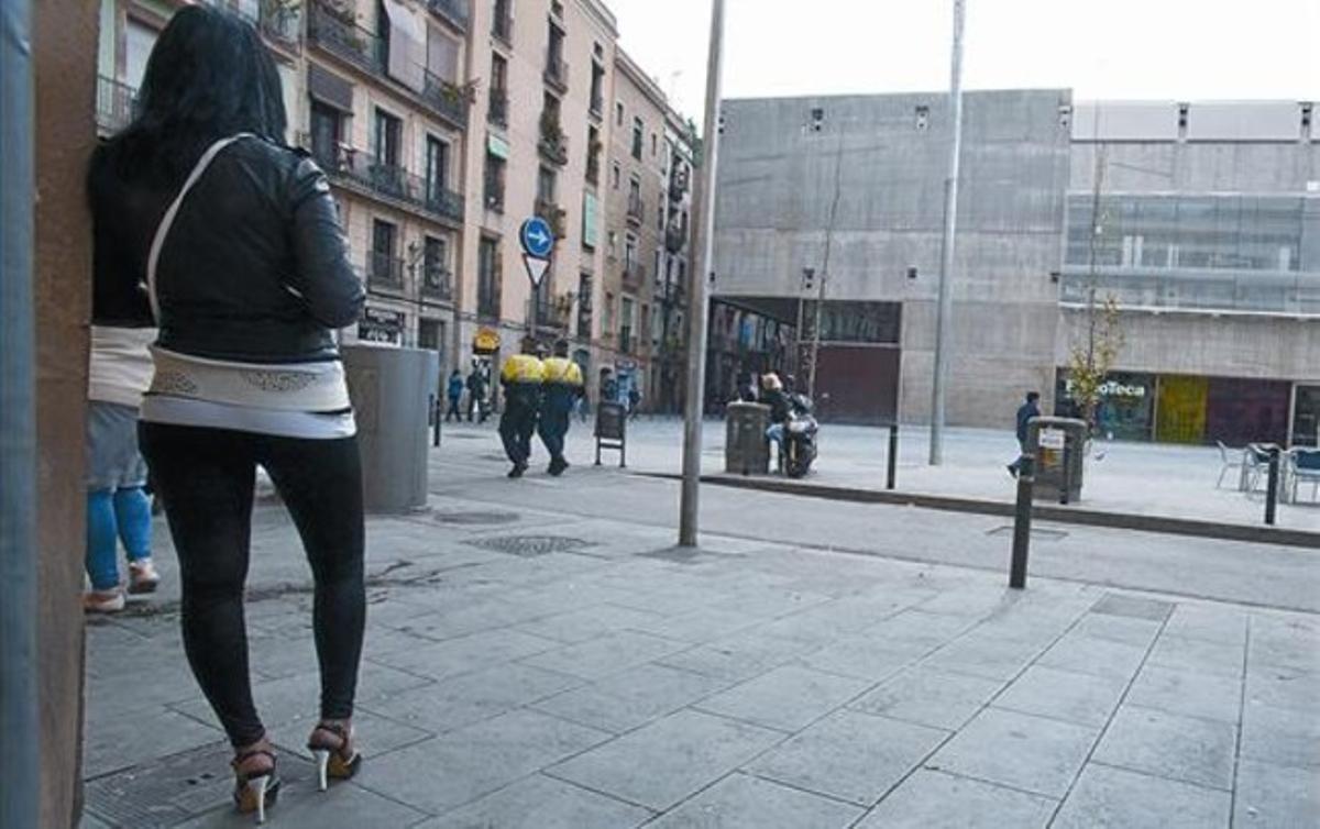 Una prostituta observa el pas de dos guàrdies al carrer d’en Robador, davant la Filmoteca, el març passat.